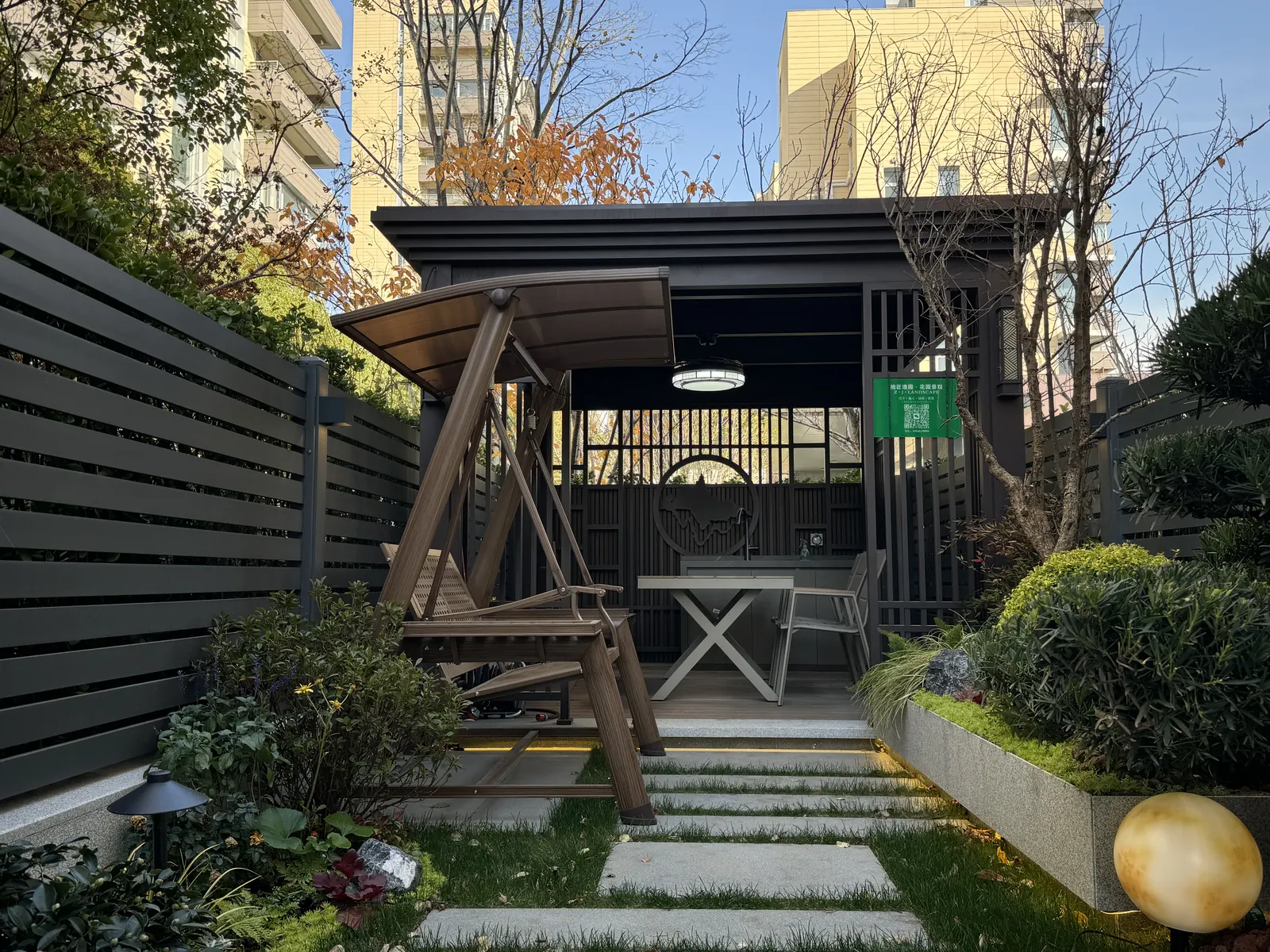 永威上和郡完工实景：廊架正面：秋千、桌椅与休闲平台构成庭院尽端的停留空间。